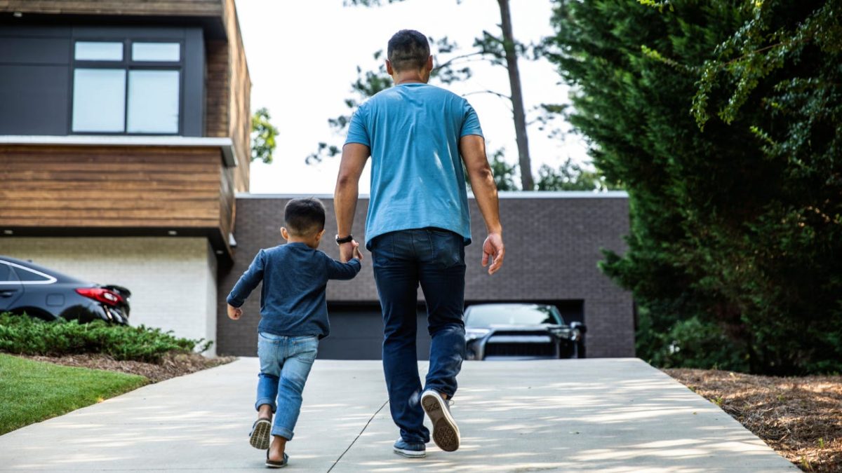 Father and son walking towards house.